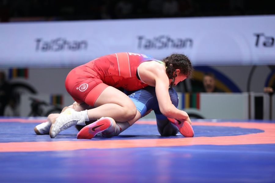 Lutteuse en maillot rouge contrôlant son adversaire au sol lors du tournoi européen de qualification olympique 2024 en lutte libre féminine