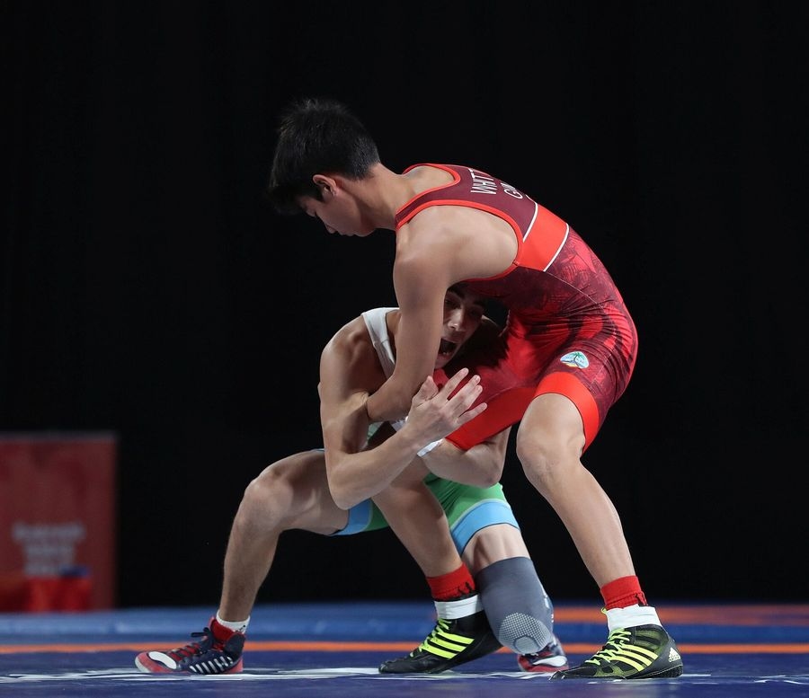 Deux jeunes lutteurs debout, l'un attaquant aux jambes, en lutte libre des moins de 55 kg aux Jeux olympiques de la jeunesse 2018 à Buenos Aires